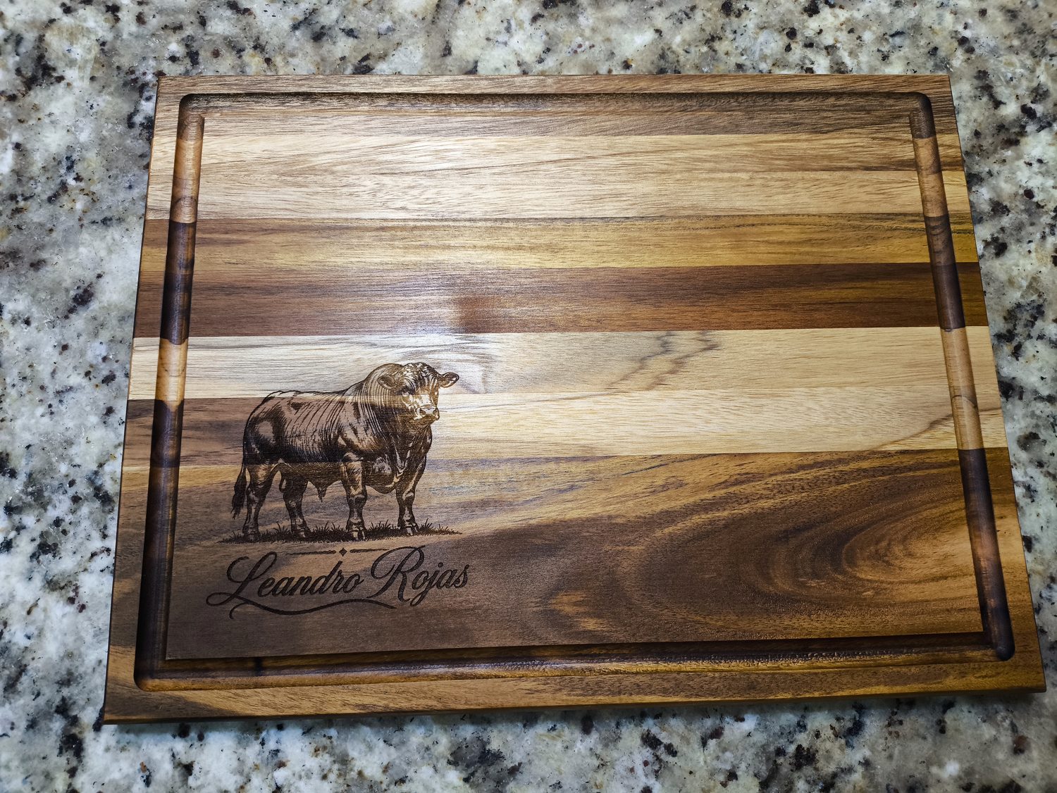 Tabla de teca con un grabado de ganado y el nombre del dueño