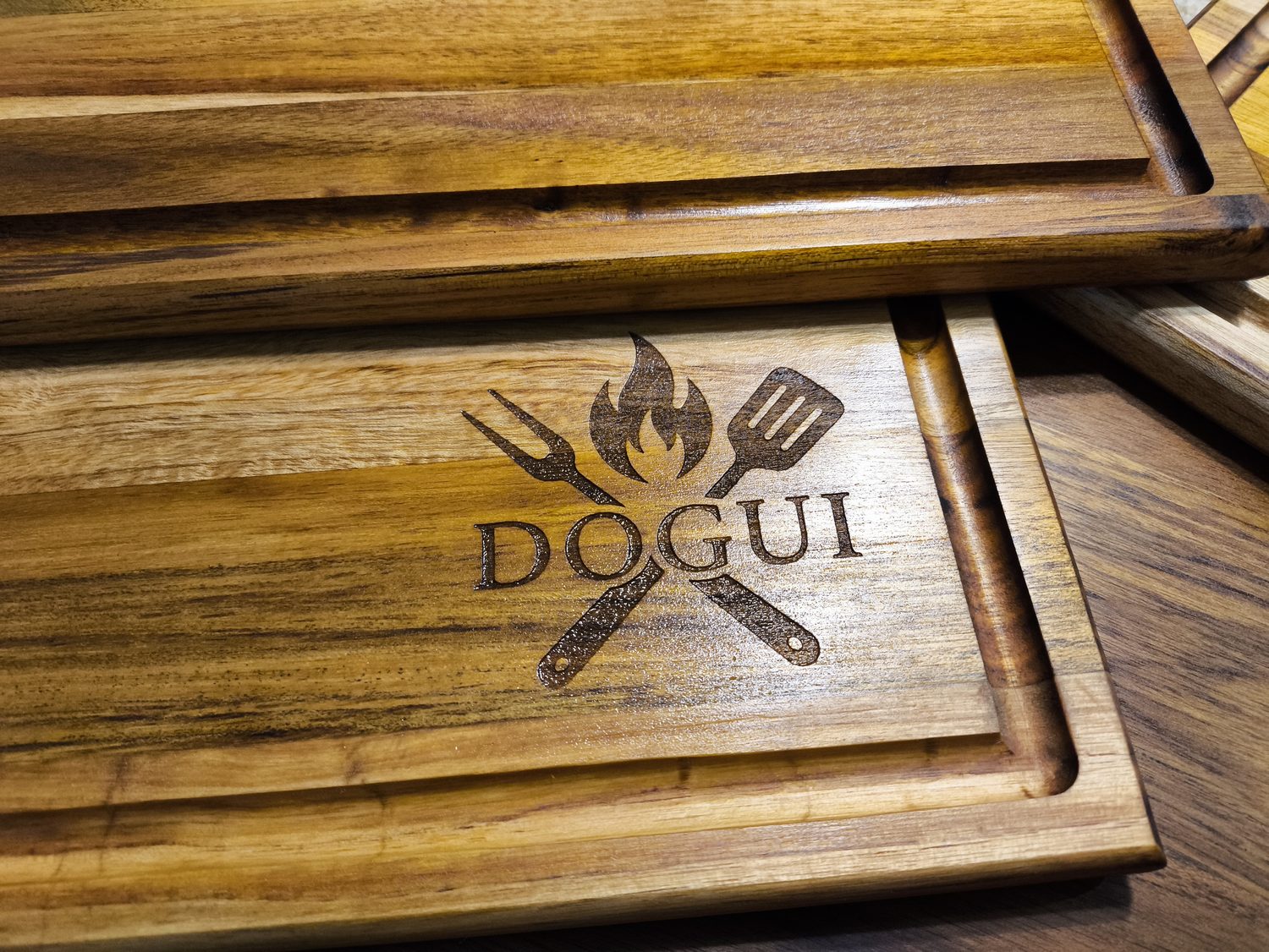 Varias tablas de teca con el mismo logo grabado, apiladas